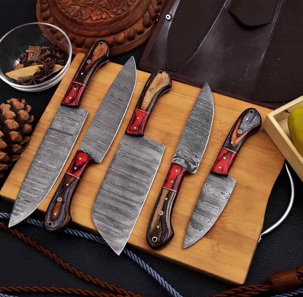 Red inlay and rivet details on handmade chef knife handles